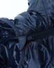 A lightweight hooded puffer jacket in navy blue, featuring a zip closure and shiny, insulated fabric.