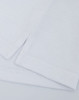 A close-up of a white cotton/poly pique fabric with folded edges, featuring a logo on the corner.