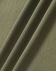 A close-up of a textured, ultrafine cotton pique fabric in olive green, featuring subtle folds.