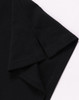 A black ultrafine cotton pique polo featuring a folded sleeve, with a small logo on the fabric.