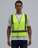 A bright yellow safety vest featuring reflective strips, worn by a model against a plain background.