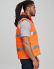 Unisex hi vis hooded puffer vest in bright orange with reflective strips, worn by a model in profile view.