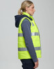 A unisex hi-vis hooded puffer vest in bright yellow with reflective stripes, worn over a navy shirt.