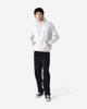 A white hooded sweatshirt worn by a young man, paired with black jeans and sneakers. The sweatshirt features a logo.