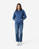 A blue hooded sweatshirt with a kangaroo pocket, paired with light blue jeans and white shoes.
