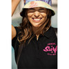 A woman wearing a black cotton polo shirt with a logo, paired with a colourful bucket hat.