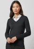 A women's Milano pullover in black, featuring a V-neck design and long sleeves, worn over a collared shirt.