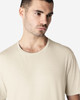 A light beige Gildan Softstyle adult t-shirt featuring a crew neck and short sleeves, displayed on a male model.