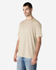 A lightweight, cream-coloured adult t-shirt displayed on a model, featuring a relaxed fit and simple design.