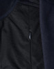 A close-up of a navy blue softshell jacket, featuring a zippered pocket and textured fabric.
