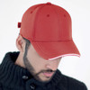A red cap with a curved brim, featuring a structured front and a branding logo on the side.