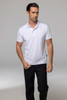 A white polo shirt modelled by a man, paired with black trousers, featuring a logo on the shirt.