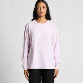 A long-sleeve T-shirt in light pink, featuring a simple design and a logo on the front. Model wears black pants.