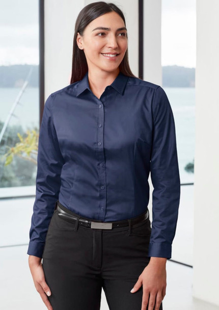 A navy long sleeve shirt with a button-up front, displayed on a woman, set against a bright window backdrop.