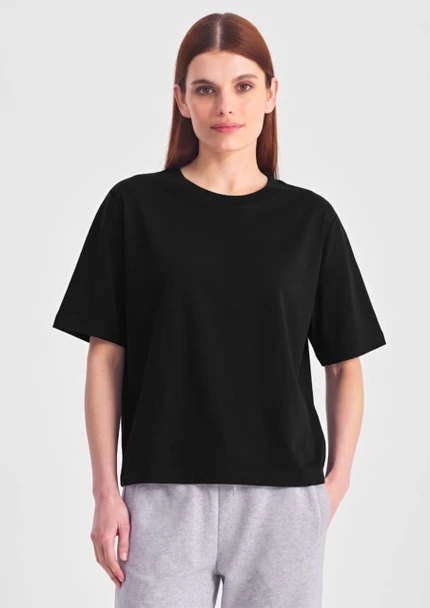 A black box tee in a relaxed fit, featuring short sleeves. The model wears it with grey bottoms.