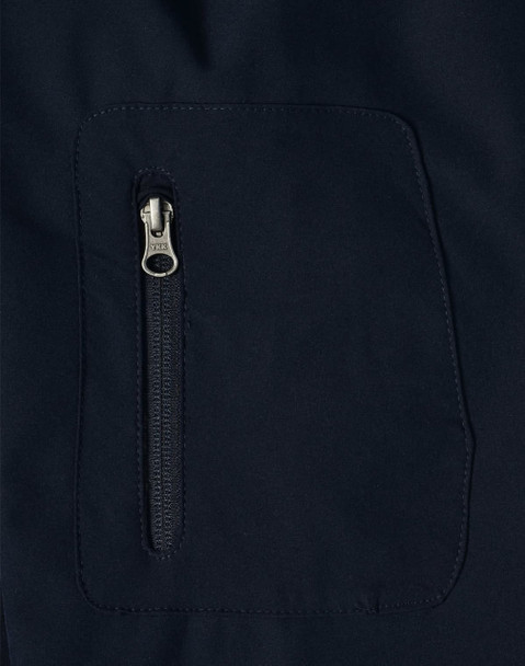 A close-up of a navy softshell jacket featuring a zippered pocket. The fabric appears smooth and durable.