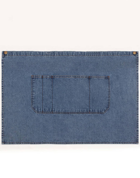 A denim half apron in blue with a front pocket and brass button accents. It has a simple, functional design.