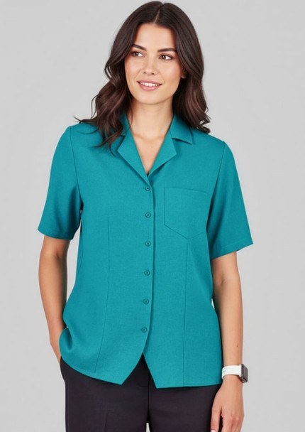 A teal overblouse with short sleeves, featuring a button-up front and a single chest pocket.