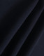 A close-up of dark navy polar fleece fabric showing soft, smooth texture folds. It features a branding logo.