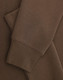A brown crew fleece jumper with visible cuffs and fabric texture detail. Features a logo.