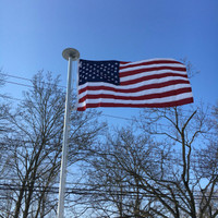 Polyester American Flag flying high and proud on 20' flagpole All 100% Made in the U.S.A.