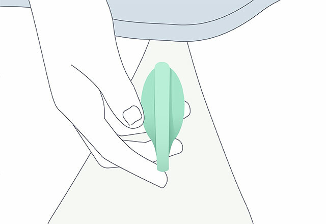 A line drawing of a woman's hand holding an Elvie trainer at her crotch. The drawing shows the top of her thighs and pubic area covered by a T-shirt