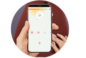 A woman's hand holds up a phone as if she is lying down and looking at the phone. Just her hand and arm, and a little of her torso and thighs, is visible