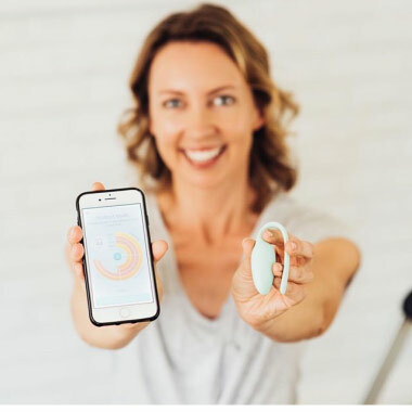 A screenshot of an Instagram post where a woman holds an Elvie trainer and a phone up to the camera