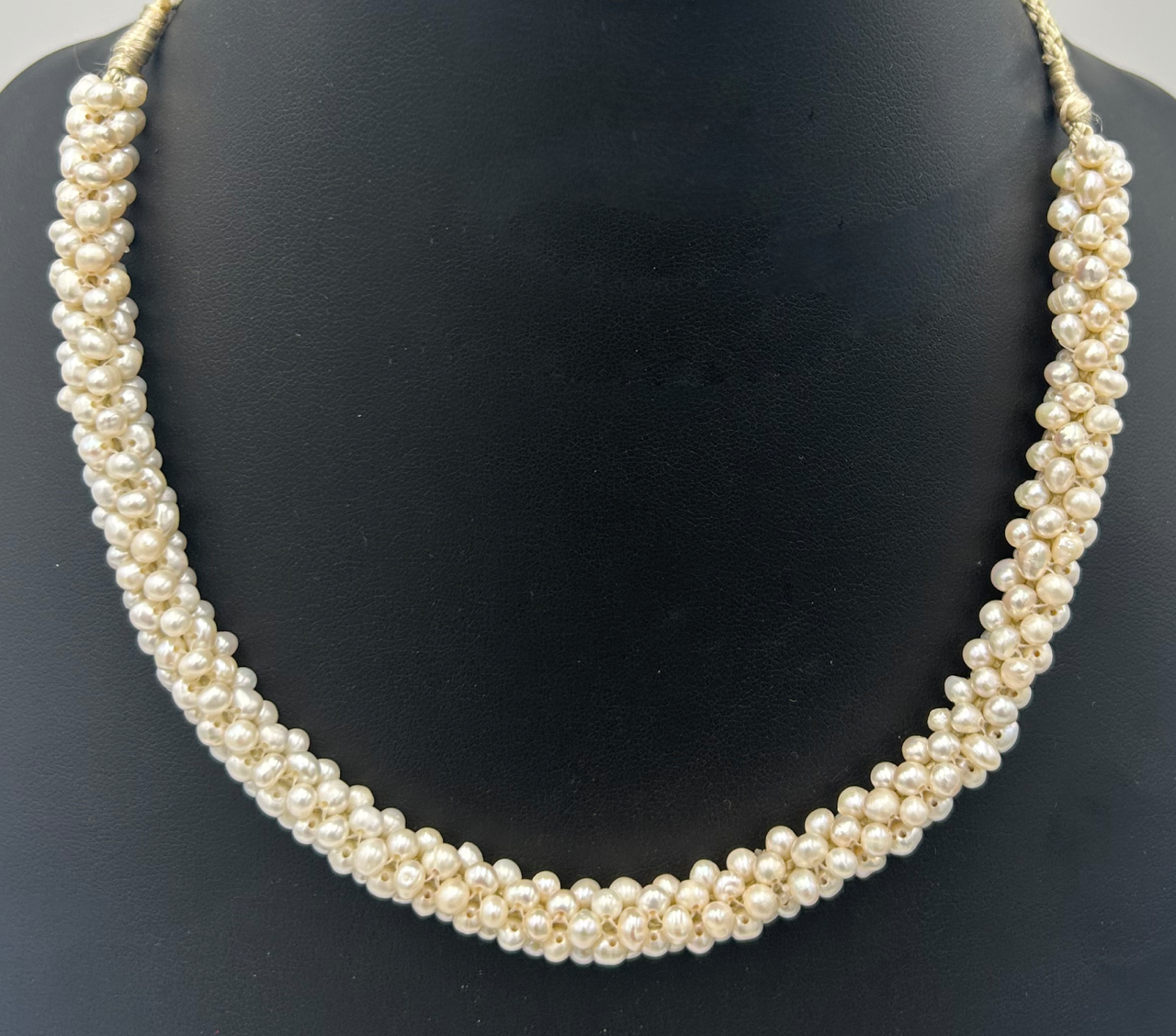 Multi-tone peacock pearl necklace on navy silk. 41