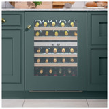 Caple WI6161 Sense Wine Cooler filled with wine bottles integrated in dark green cabinets