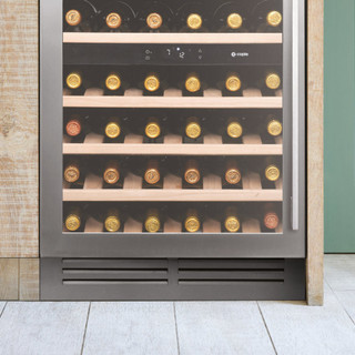 Caple GRILL/CLASS601 60cm Plinth Grille installed below a wine cooler in a pastel green kitchen