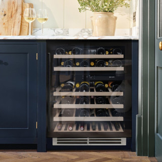 Black glass Caple WI6136BG Sense Wine Cabinet seamlessly integrated into a navy blue kitchen with ma