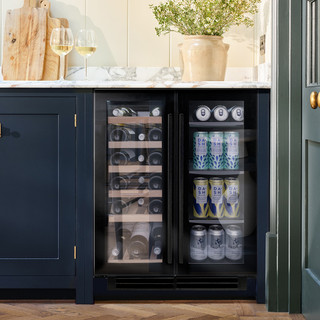 Caple WI6235BG Sense Wine Cabinet in black glass seamlessly integrated into a navy blue kitchen with