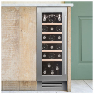 Caple WI3125 30cm Stainless Steel Wine Cooler filled with wine bottles in a green, wooden kitchen