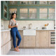 Woman leaning on kitchen counter with Caple CPBS4 60cm Belfast Sink holding cup in a bright green an