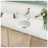 Caple's CPWIB3 Warwickshire Ceramic Kitchen Sink inset into marble countertop with plants nearby