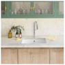 Caple Flutier Kitchen Tap installed on a marble countertop below green cabinets with plants and glas
