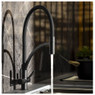 Genio Semi Professional Kitchen Tap in black with dual levers on display against granite splashback