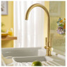 Abode Globe Monobloc Kitchen Tap in brass over white sink with lime on countertop in yellow kitchen