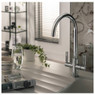 Abode Modern Globe Aquifier Water Filter Tap in use with a glass of water and plant on countertop