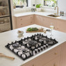 Caple C4071G Gas Hob in a modern kitchen with pink cabinets, wine on marble countertop.