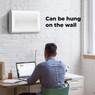 Man using Aeno AP2S air purifier hung on a wall in a quiet office workspace.