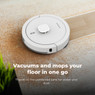 Aeno RC4S robot vacuum cleaner actively cleaning crumbs a hardwood floor.