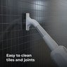 Aeno Steam Mop effortlessly cleaning tiles and grout on a tiled wall.