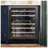 Caple WI6135 60cm wine cooler with glass door revealing stocked wine bottles in a modern blue kitche