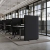 Muffle 50 freestanding acoustic screen in black beside an office desk
