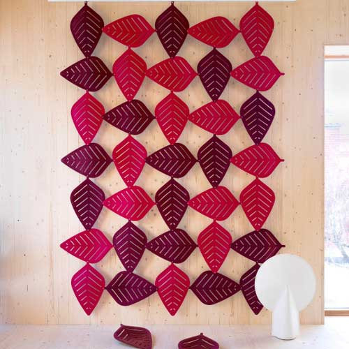 The Abstracta Airleaf gives an oasis appearance to the suspended sound-absorbing ceiling isle complementing open space offices - pink and violet leaves - asymmetric design - in office.