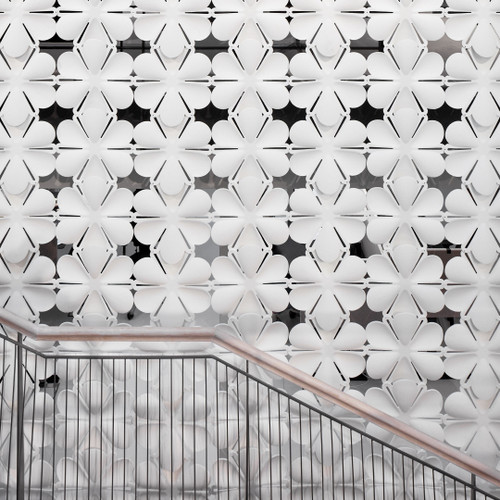 The Abstracta Airbloom Hanging Screen refresh the office environment by the flower shaped like panels - white panels in front of the stairs - front view - in office.