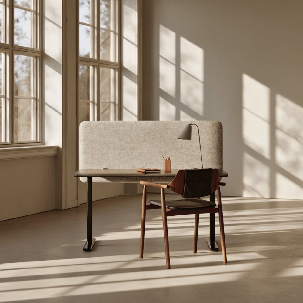 Light grey acoustic desk screen on a desk in a sunlit office