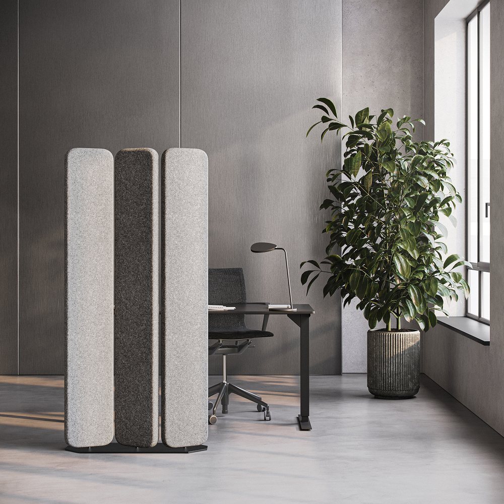 Freestanding acoustic floor screens beside a desk in a modern office